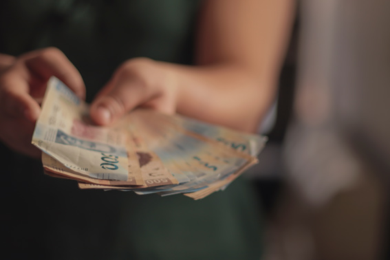 Hand holding Mexican peso banknotes