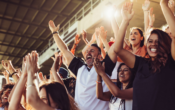 Crowd of football fans cheering during a match in stadium