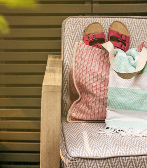 Sandals and a towel in a beach bag