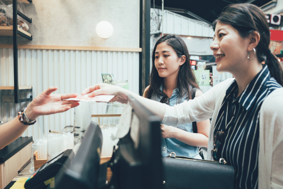 Customer handing over Japanese yen at a till