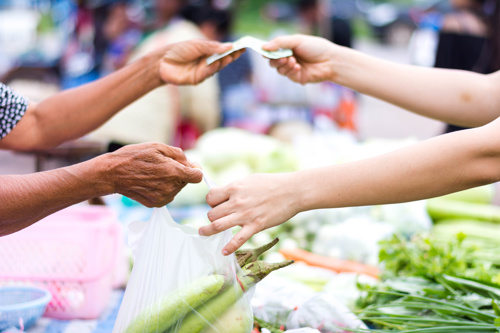 Customer paying in baht at a Thai market
