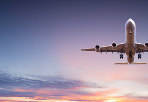 Commercial airplane jetliner flying above dramatic clouds.