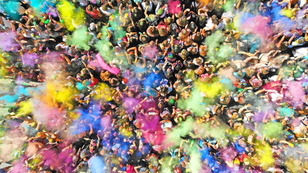 Aerial top view of a Holi Colors Festival. Splash of paint in a crowd of people view above.